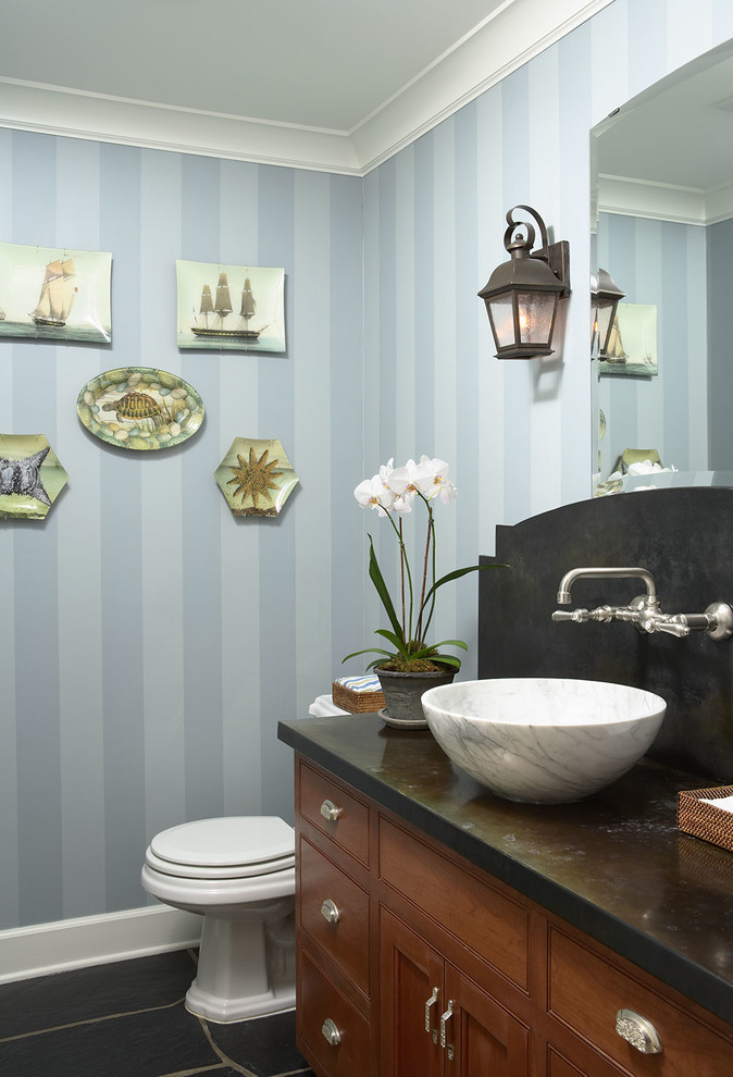 Foto di un bagno di servizio classico con lavabo a bacinella, top in marmo, pavimento nero, top nero, ante a filo, ante in legno scuro e pareti blu
