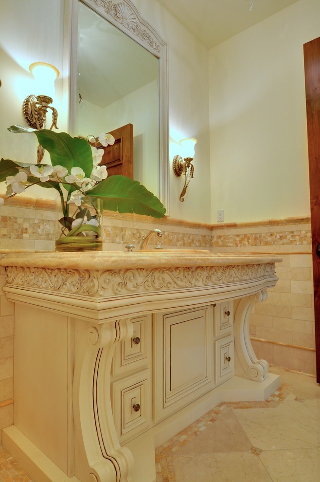 Klassisk inredning av ett litet toalett, med möbel-liknande, skåp i slitet trä, vita väggar, linoleumgolv, ett nedsänkt handfat och marmorbänkskiva