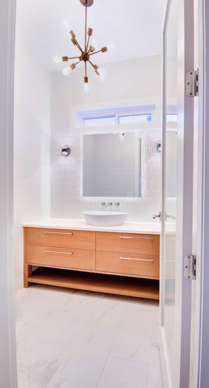 This is an example of a medium sized contemporary cloakroom in Vancouver with raised-panel cabinets, light wood cabinets, a one-piece toilet, white tiles, ceramic tiles, white walls, ceramic flooring, a vessel sink and quartz worktops.