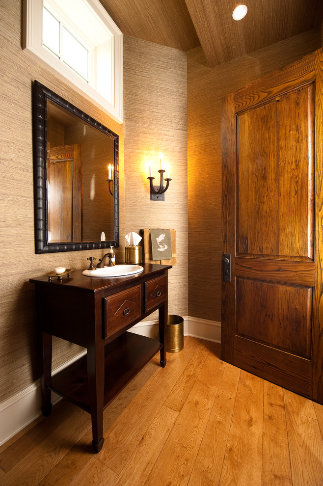 На фото: туалет в классическом стиле с накладной раковиной, фасадами островного типа и темными деревянными фасадами