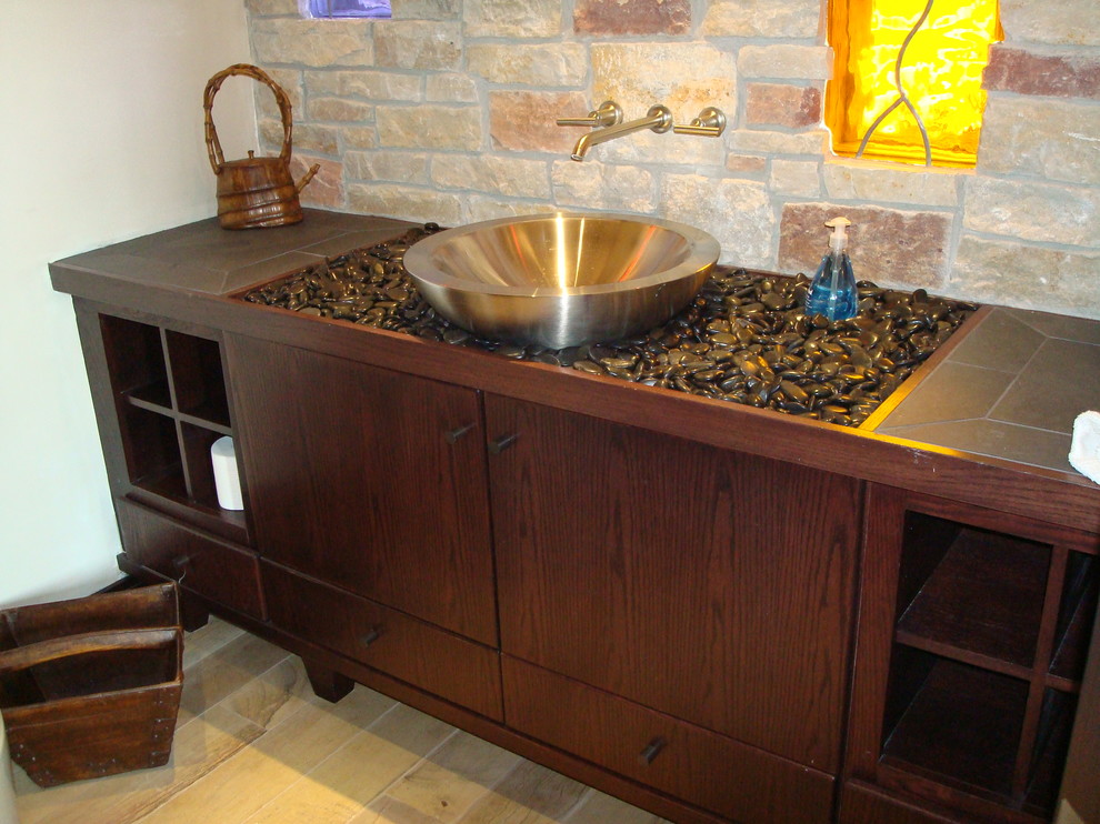 Photo of a contemporary cloakroom in Chicago with a vessel sink, freestanding cabinets, dark wood cabinets, tiled worktops, a one-piece toilet and stone tiles.