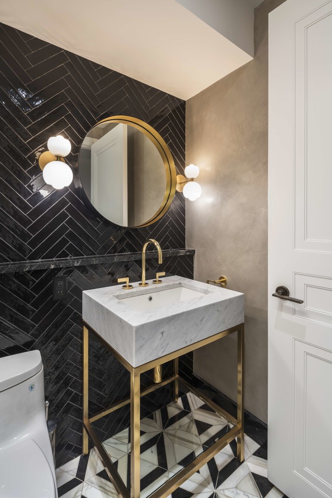 Powder room - large contemporary black tile multicolored floor powder room idea in New York with a one-piece toilet, gray walls, a console sink and gray countertops