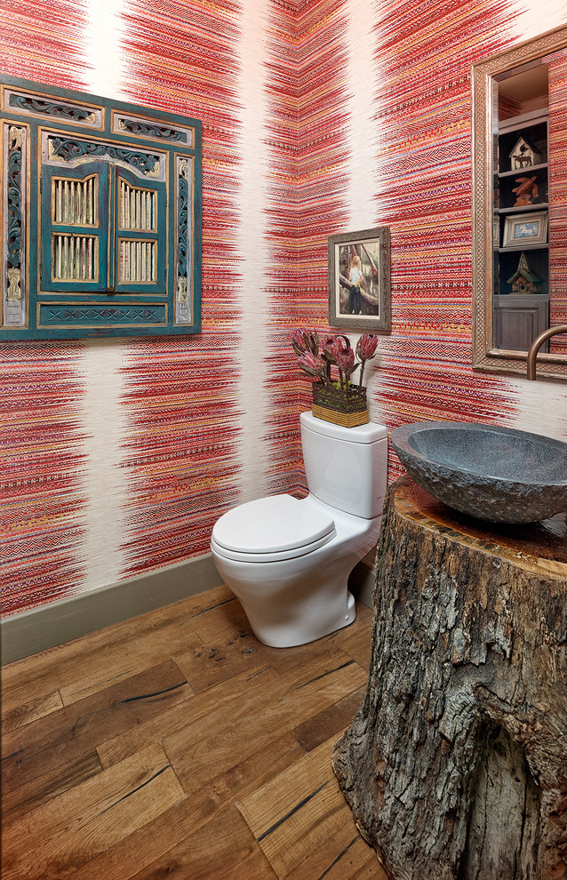 Mid-sized southwest red tile medium tone wood floor and brown floor powder room photo in Dallas with beaded inset cabinets, gray cabinets, a one-piece toilet, red walls, a vessel sink, wood countertops and brown countertops