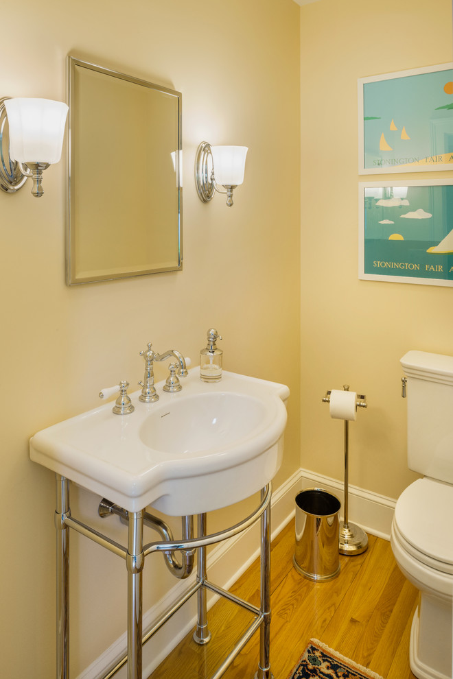 Стильный дизайн: маленький туалет в классическом стиле с желтыми стенами, светлым паркетным полом и монолитной раковиной для на участке и в саду - последний тренд