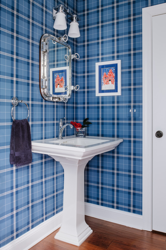 Idee per un bagno di servizio stile marinaro con pareti blu, pavimento in legno massello medio, lavabo a colonna e pavimento marrone