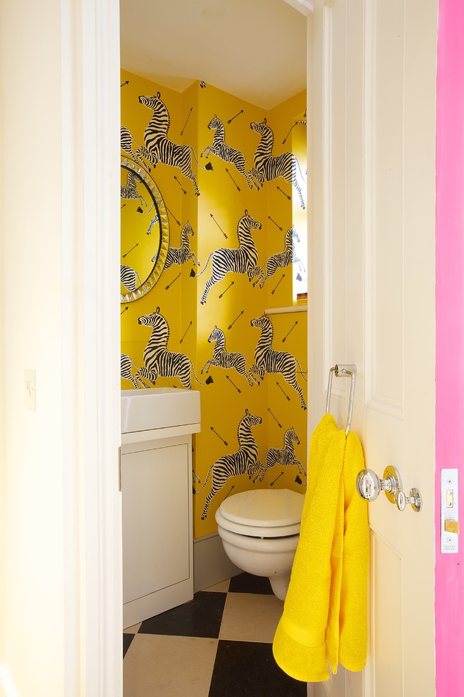 Inspiration for an eclectic cloakroom in London with flat-panel cabinets, white cabinets, a wall mounted toilet, yellow walls, porcelain flooring and a vessel sink.