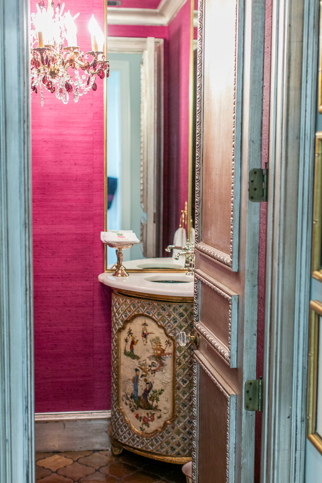 Idee per un piccolo bagno di servizio eclettico con consolle stile comò, pareti rosa, pavimento in terracotta, lavabo sottopiano, top in marmo e pavimento marrone