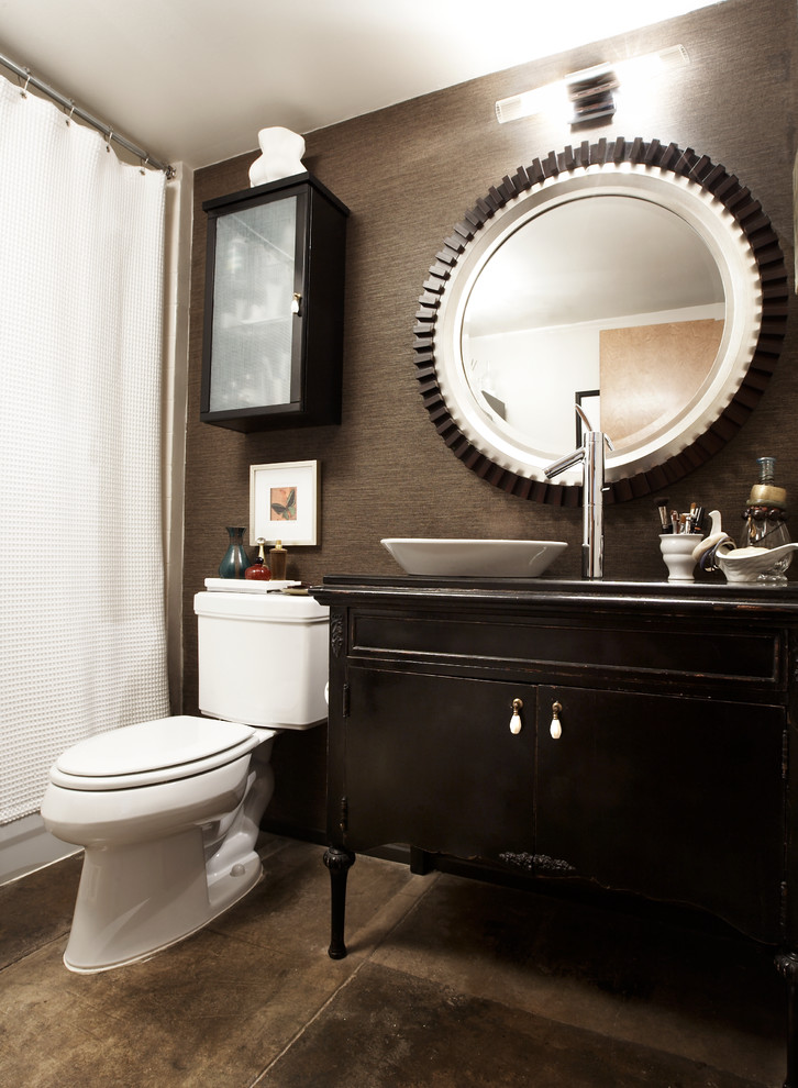 Example of a small eclectic brown tile powder room design in Dallas with a vessel sink, dark wood cabinets, wood countertops, a one-piece toilet, brown walls and furniture-like cabinets