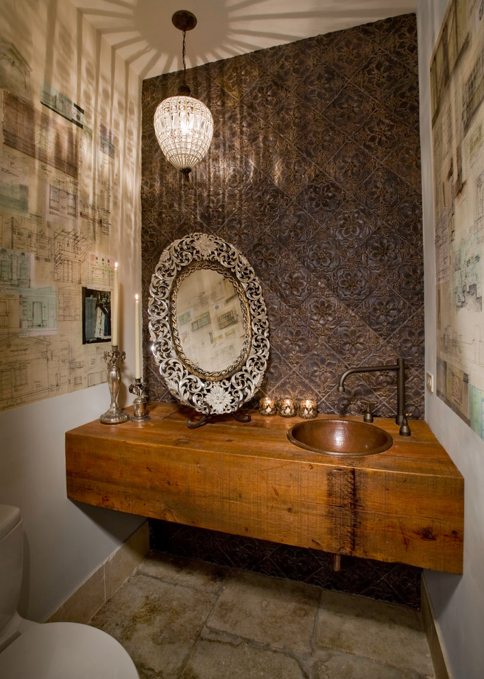 Imagen de aseo ecléctico con lavabo encastrado, puertas de armario de madera oscura, encimera de madera, baldosas y/o azulejos marrones y encimeras marrones
