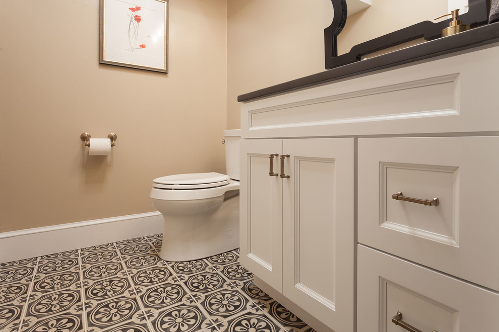 Medium sized eclectic cloakroom in DC Metro with shaker cabinets, white cabinets, a two-piece toilet, beige walls, porcelain flooring, a submerged sink, engineered stone worktops, green floors and black worktops.