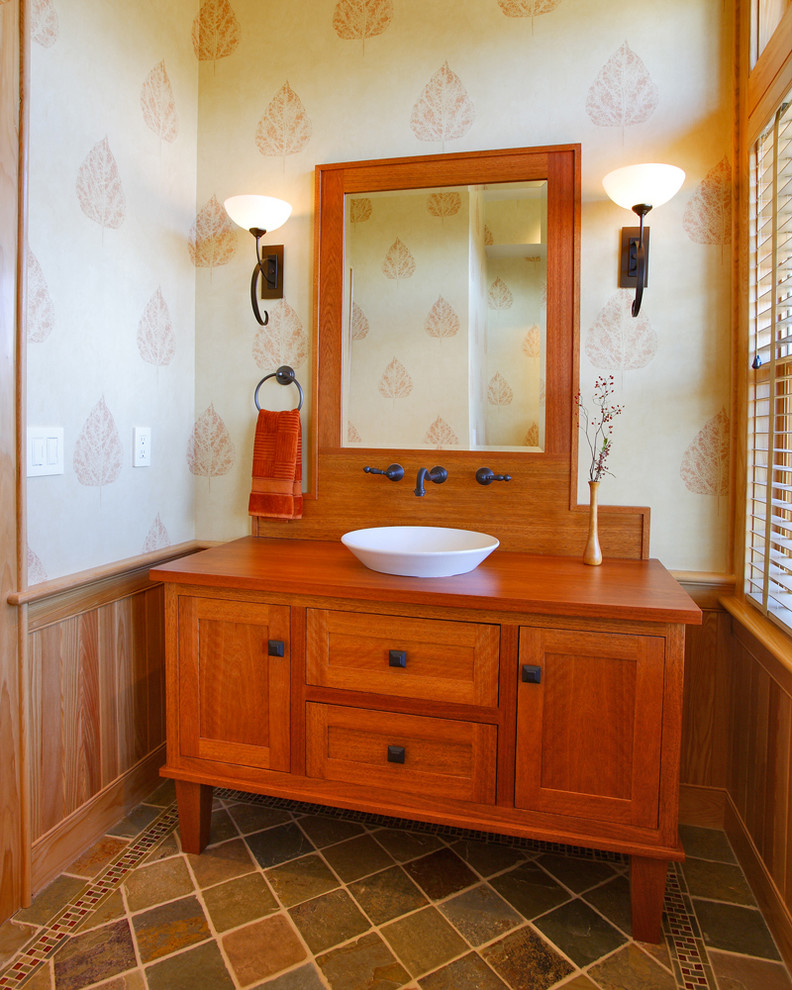Пример оригинального дизайна: туалет среднего размера с фасадами в стиле шейкер, фасадами цвета дерева среднего тона, зеленой плиткой, каменной плиткой, полом из сланца, настольной раковиной и столешницей из дерева