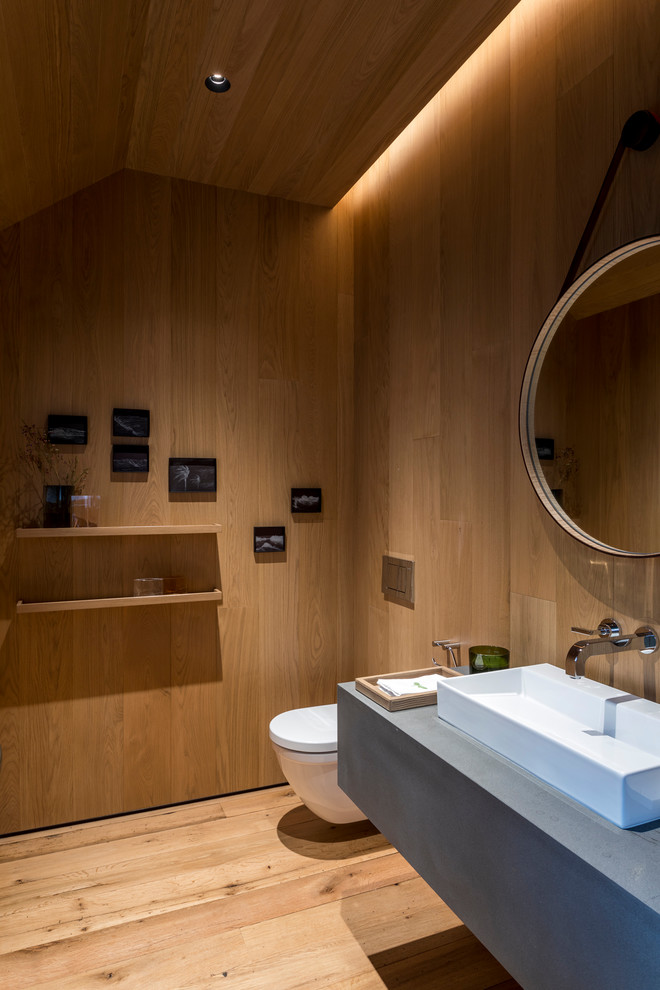 Idées déco pour un grand WC suspendu contemporain avec un sol en bois brun, un plan vasque, un mur marron, un plan de toilette en quartz, un sol marron et un plan de toilette gris.