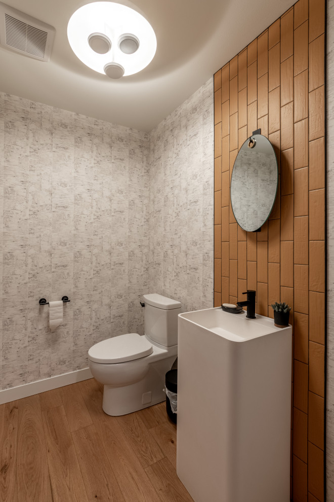 Inspiration pour un WC et toilettes design avec un placard à porte plane, des portes de placard blanches, WC séparés, un mur gris, un sol en bois brun, un lavabo de ferme, un sol marron et un plan de toilette blanc.