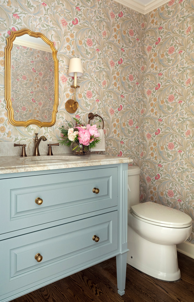 Inspiration for a medium sized traditional cloakroom in Minneapolis with freestanding cabinets, blue cabinets, multi-coloured walls, dark hardwood flooring, a submerged sink, brown floors, multi-coloured worktops, a one-piece toilet, marble worktops, a built in vanity unit and wallpapered walls.