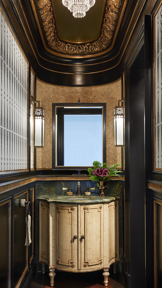 Kleine Mediterrane Gästetoilette mit verzierten Schränken, hellen Holzschränken, beigen Fliesen, Glasfliesen, dunklem Holzboden, Granit-Waschbecken/Waschtisch und braunem Boden in Minneapolis