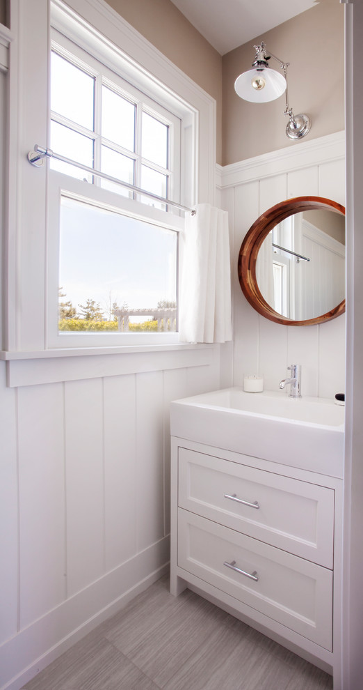 Example of a beach style gray floor powder room design in Boston with furniture-like cabinets, white cabinets, beige walls and a console sink