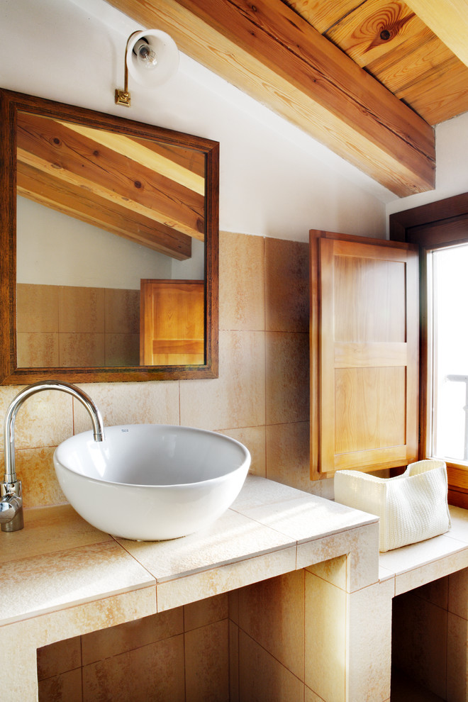 Immagine di un piccolo bagno di servizio rustico con piastrelle beige, piastrelle in ceramica, pareti bianche, lavabo a bacinella e top piastrellato