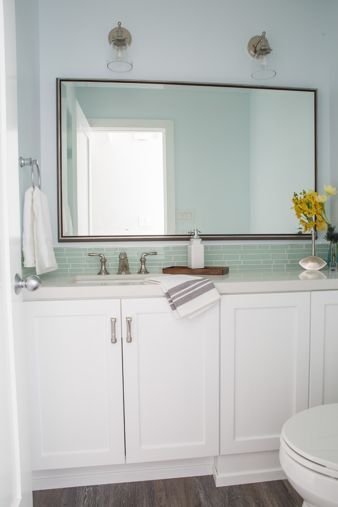 Inspiration for a small coastal green tile and glass tile vinyl floor powder room remodel in Los Angeles with a one-piece toilet, an undermount sink, quartz countertops and recessed-panel cabinets
