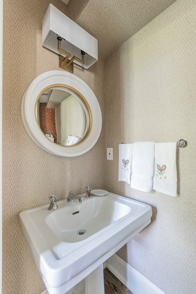 Example of a mid-sized transitional dark wood floor and brown floor powder room design in Philadelphia with a two-piece toilet, beige walls and a pedestal sink