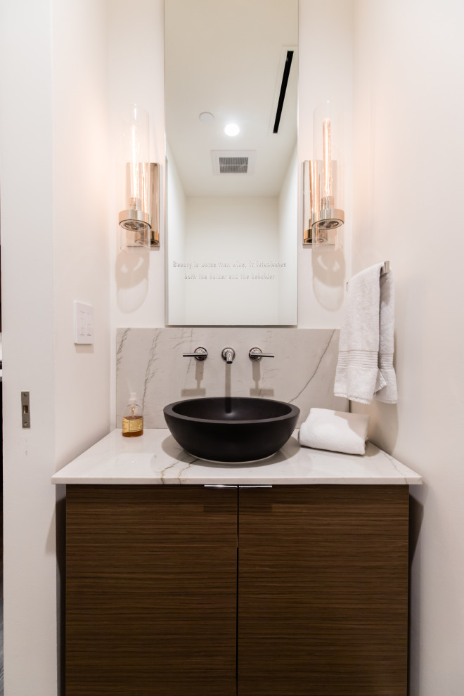 This is an example of a small modern cloakroom in Dallas with flat-panel cabinets, dark wood cabinets, a two-piece toilet, white tiles, white walls, dark hardwood flooring, a vessel sink, marble worktops, brown floors and white worktops.
