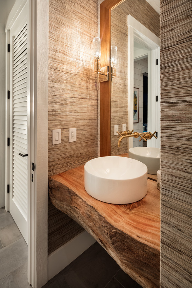 This is an example of a small beach style cloakroom in Hawaii with open cabinets, light wood cabinets, a one-piece toilet, white tiles, mosaic tiles, white walls, ceramic flooring, a vessel sink, wooden worktops, grey floors and brown worktops.