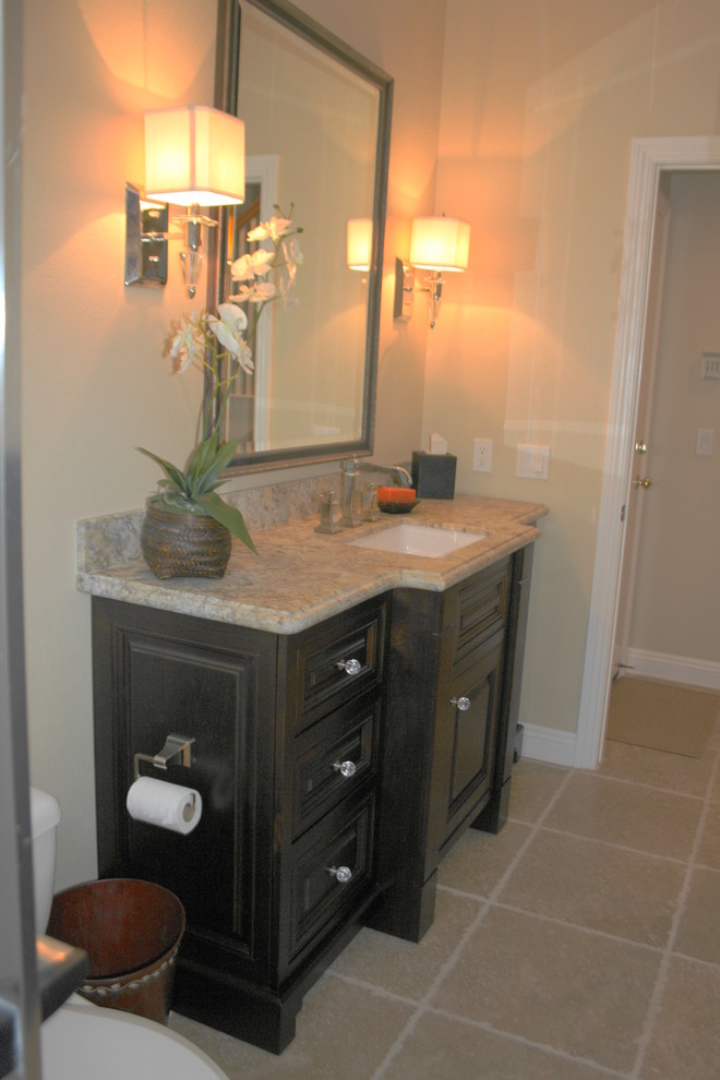 This is an example of a contemporary cloakroom in San Diego with raised-panel cabinets, dark wood cabinets, beige tiles, stone tiles, beige walls, travertine flooring, a submerged sink and granite worktops.