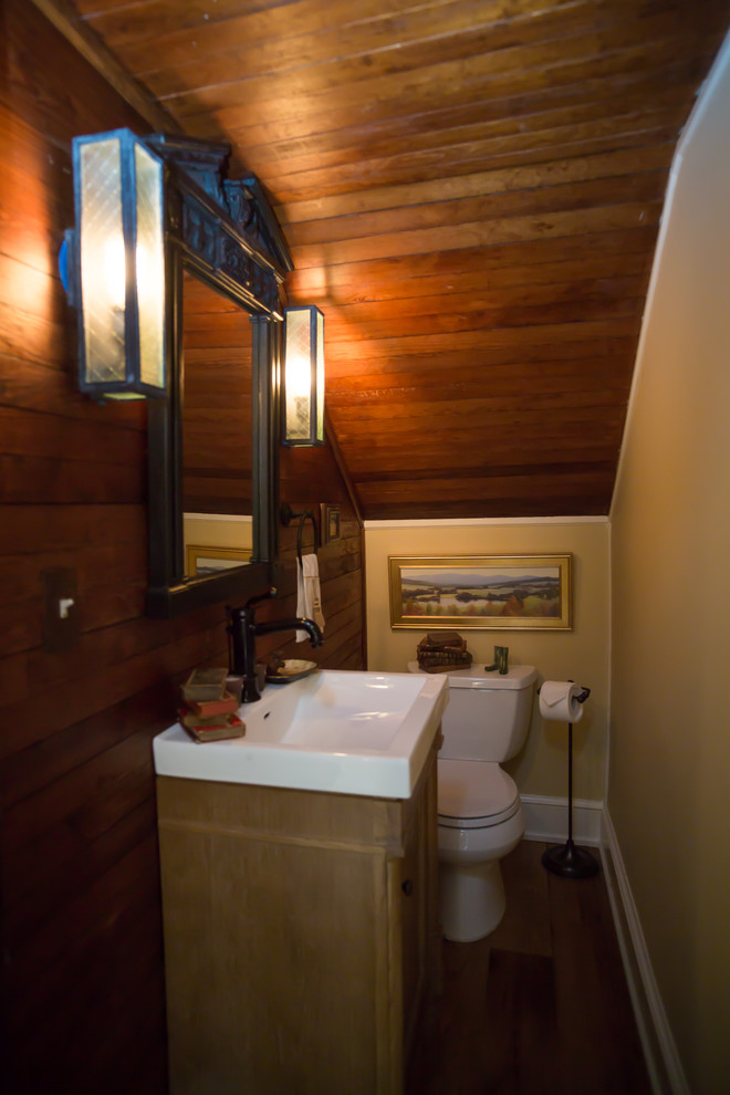 ワシントンD.C.にあるお手頃価格の小さなカントリー風のおしゃれなトイレ・洗面所 (一体型トイレ	、茶色い壁、一体型シンク、茶色い床、茶色いタイル、濃色無垢フローリング、人工大理石カウンター) の写真