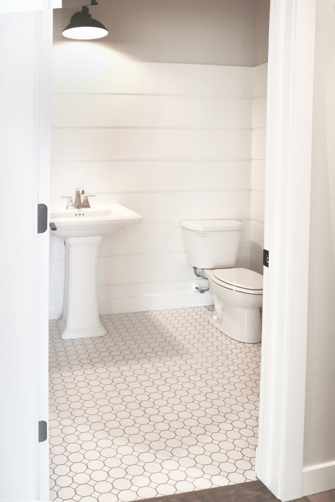 Esempio di un bagno di servizio stile americano di medie dimensioni con WC monopezzo, pareti grigie, pavimento con piastrelle a mosaico, lavabo a colonna e pavimento bianco