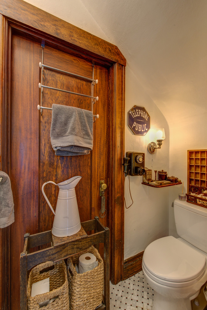 Idee per un bagno di servizio stile americano di medie dimensioni con ante in legno bruno, WC a due pezzi, pareti beige, pavimento in marmo e pavimento bianco