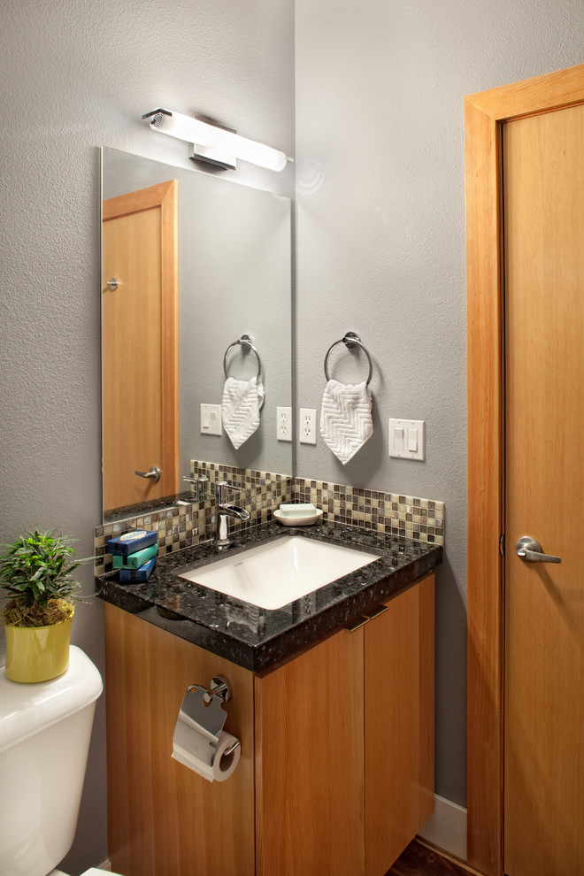 Immagine di un bagno di servizio design con lavabo sottopiano, top in granito, piastrelle multicolore, piastrelle a mosaico e pareti grigie