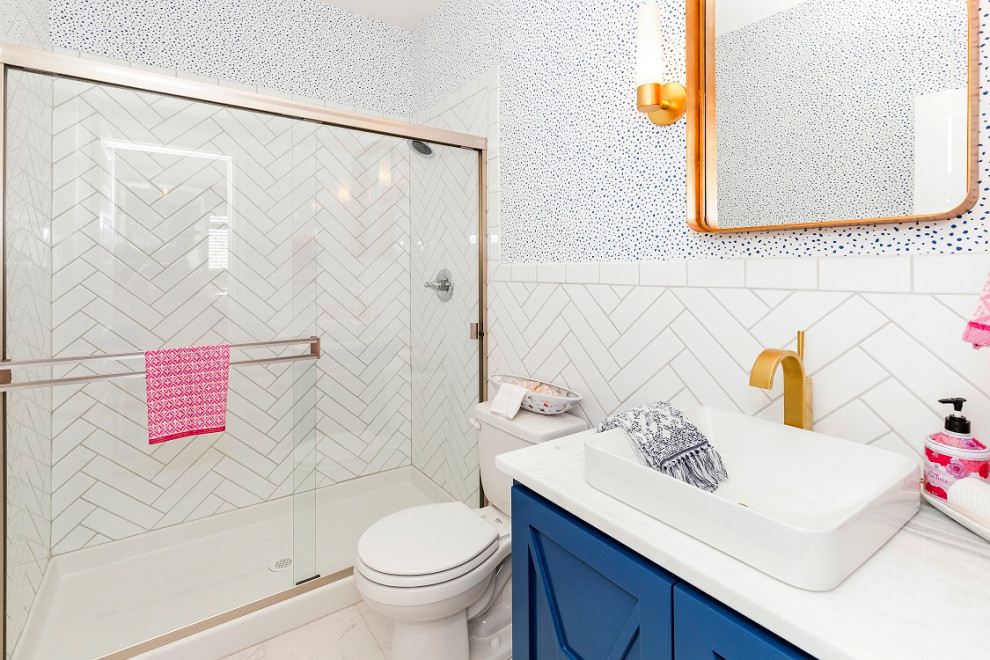 Photo of a medium sized traditional cloakroom in Kansas City with freestanding cabinets, blue cabinets, a one-piece toilet, multi-coloured tiles, ceramic tiles, blue walls, ceramic flooring, a pedestal sink, granite worktops, grey floors and grey worktops.