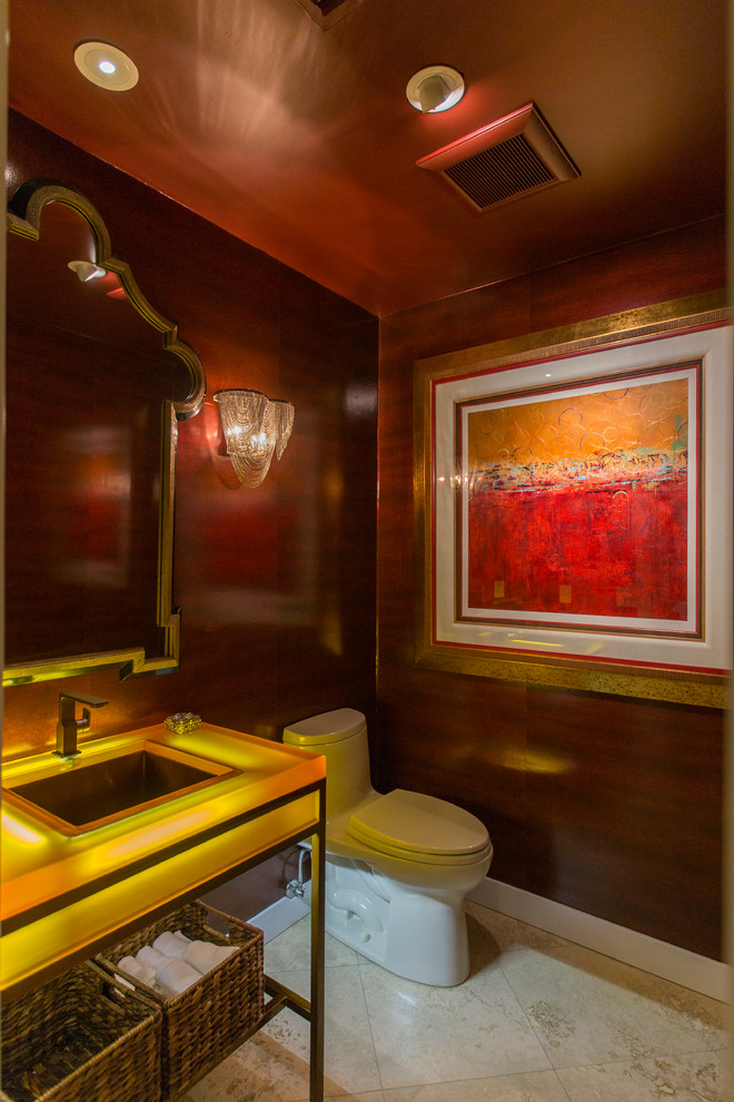 На фото: туалет среднего размера в стиле фьюжн с фасадами островного типа, унитазом-моноблоком, коричневыми стенами, полом из травертина, врезной раковиной, стеклянной столешницей, бежевым полом и желтой столешницей с