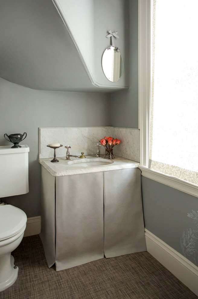 Aménagement d'un petit WC et toilettes classique avec un mur gris, un lavabo encastré, un plan de toilette en marbre et WC séparés.