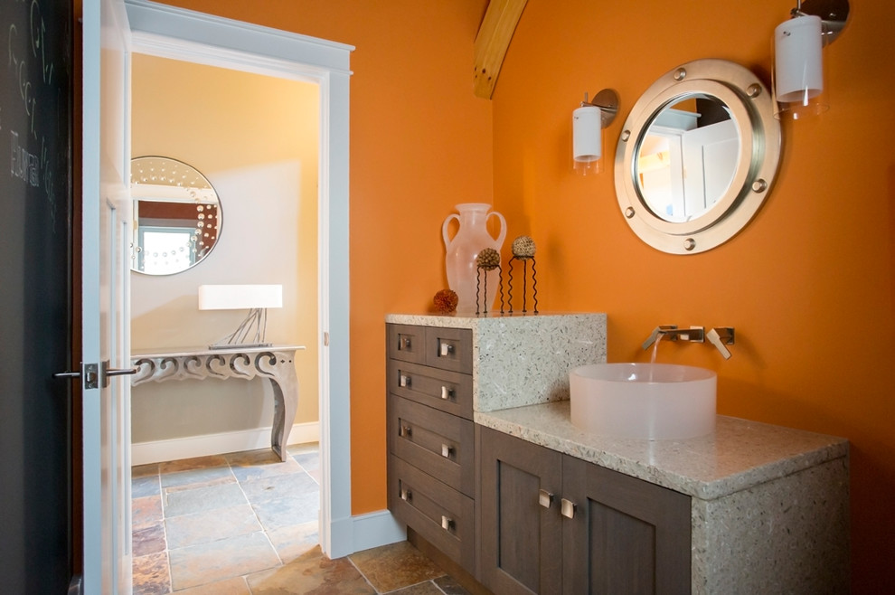 Example of a mid-sized trendy porcelain tile and multicolored floor powder room design in Jacksonville with a vessel sink, recessed-panel cabinets, dark wood cabinets, orange walls, gray countertops and terrazzo countertops