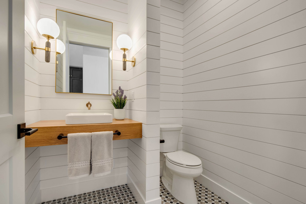 Idée de décoration pour un WC et toilettes champêtre de taille moyenne avec un mur blanc, un sol en carrelage de porcelaine, une vasque, un plan de toilette en bois, un sol multicolore, meuble-lavabo suspendu et du lambris de bois.