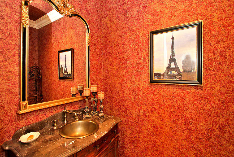 Imagen de aseo clásico pequeño con lavabo encastrado, armarios tipo mueble, puertas de armario de madera oscura, encimera de mármol, sanitario de una pieza y paredes rojas
