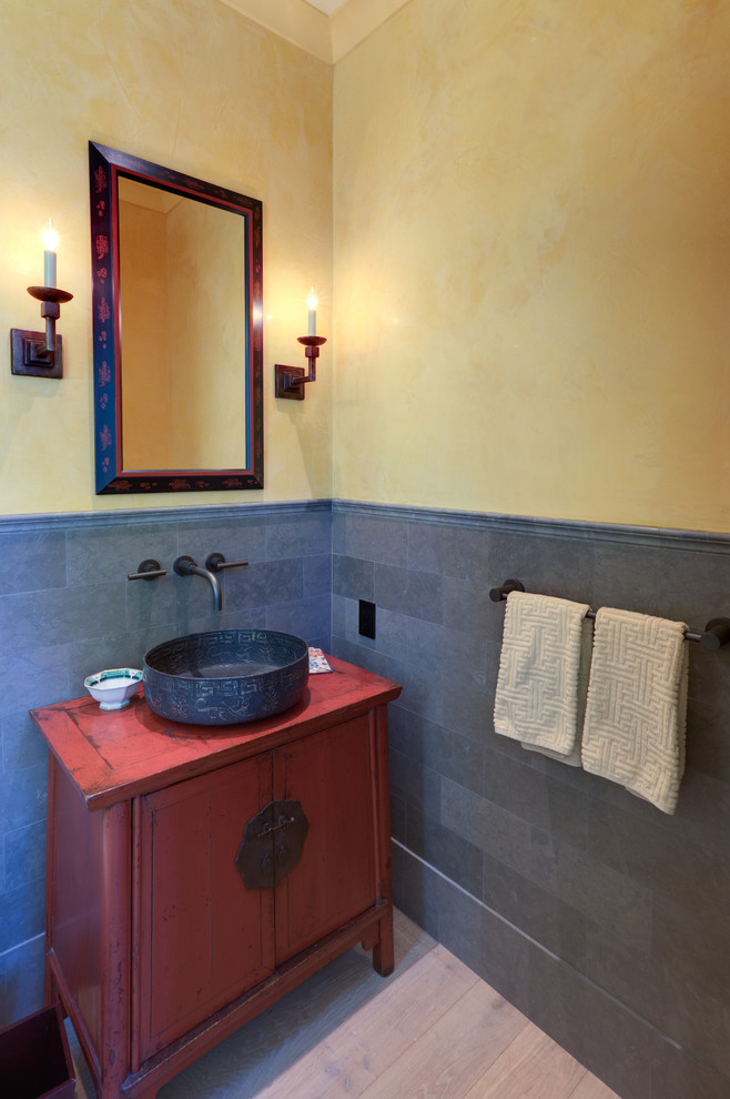Exempel på ett asiatiskt toalett, med ett fristående handfat, grå kakel, stenkakel, gula väggar, ljust trägolv, skåp i slitet trä och möbel-liknande