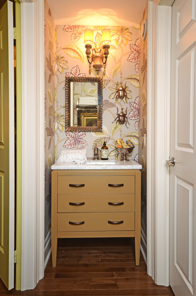 Inspiration pour un petit WC et toilettes vintage avec un lavabo encastré, des portes de placard beiges, un plan de toilette en marbre, un mur multicolore et parquet foncé.