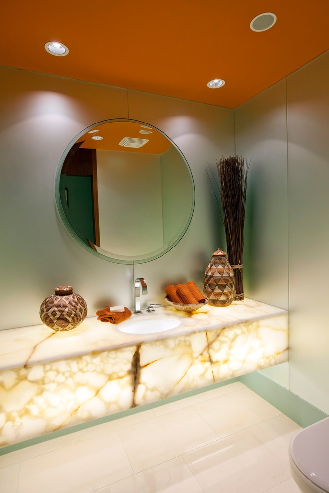 Inspiration för mellanstora medelhavsstil beige toaletter, med ett undermonterad handfat och beiget golv
