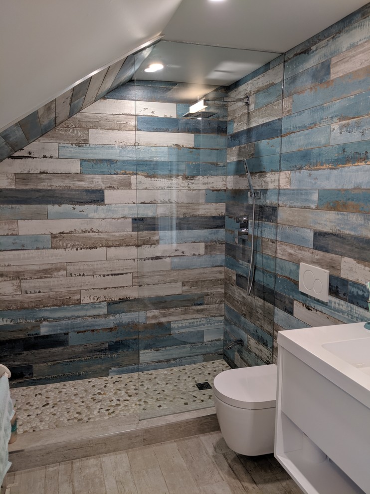 Medium sized coastal cloakroom in Toronto with open cabinets, white cabinets, a wall mounted toilet, multi-coloured tiles, ceramic tiles, multi-coloured walls, ceramic flooring, an integrated sink, solid surface worktops, beige floors and yellow worktops.
