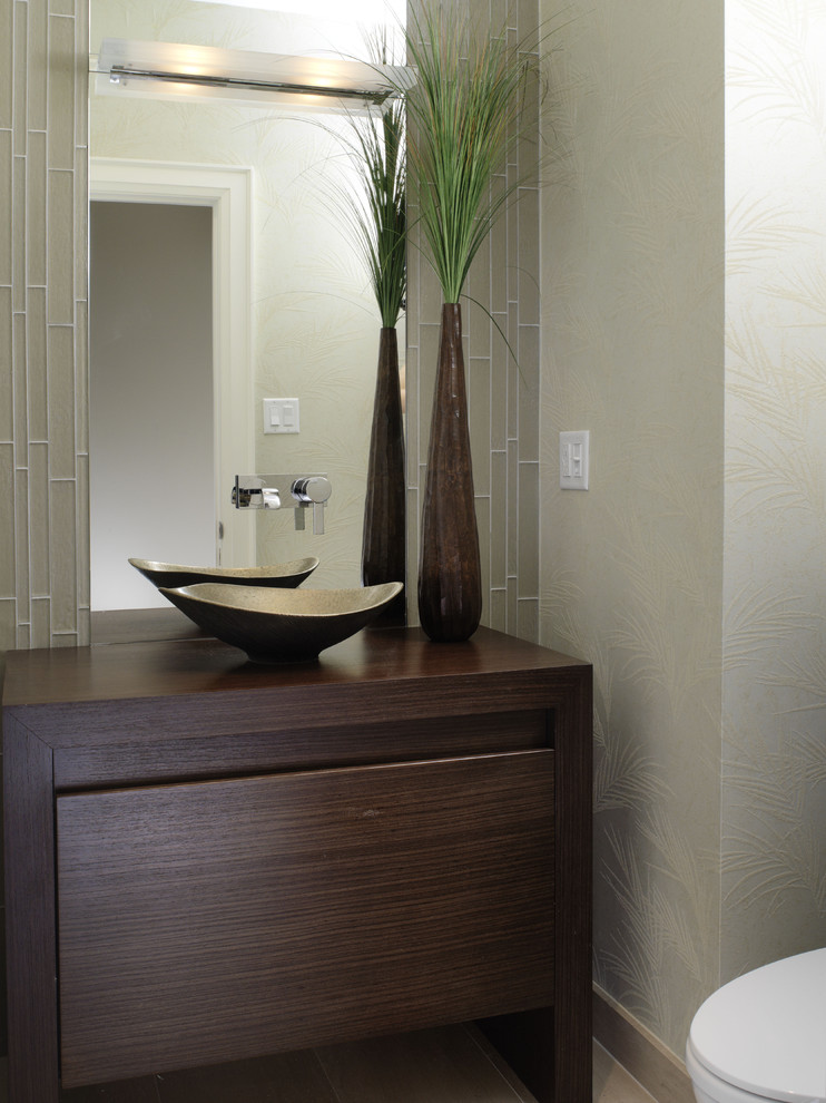 Idée de décoration pour un WC et toilettes asiatique avec une vasque, un placard à porte plane, un plan de toilette en bois, un carrelage en pâte de verre, un mur vert, un sol en calcaire, un carrelage gris et un plan de toilette marron.