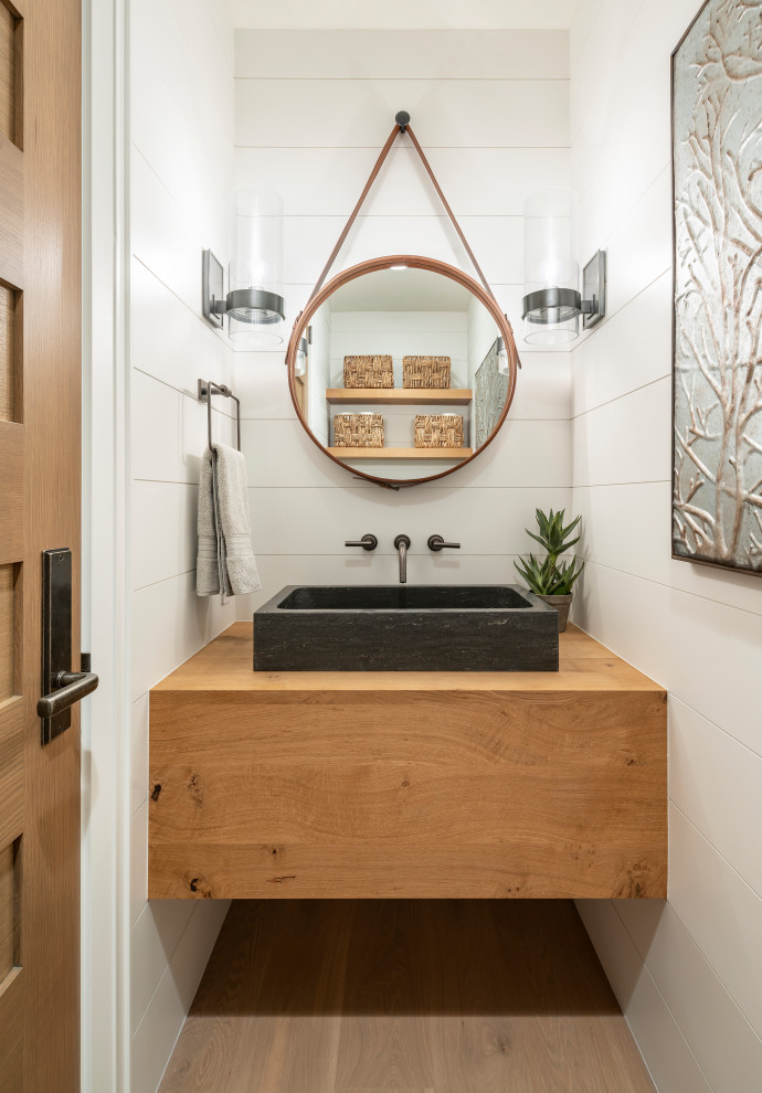 ソルトレイクシティにあるラグジュアリーな小さなカントリー風のおしゃれなトイレ・洗面所 (白い壁、ベッセル式洗面器、木製洗面台、ブラウンの洗面カウンター、無垢フローリング、茶色い床) の写真