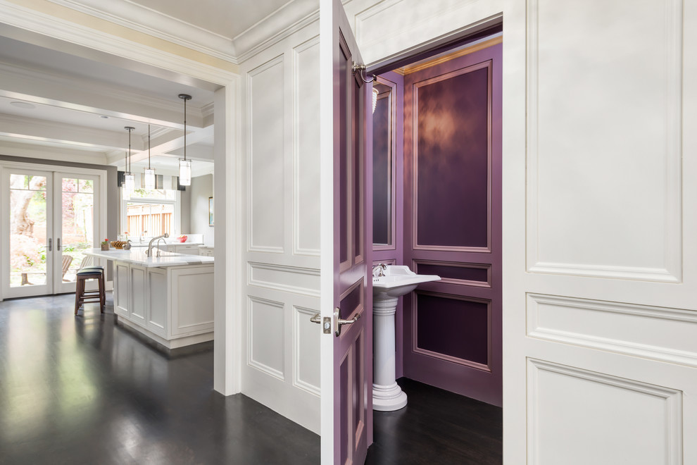 Идея дизайна: туалет в классическом стиле с раковиной с пьедесталом, фиолетовыми стенами и темным паркетным полом