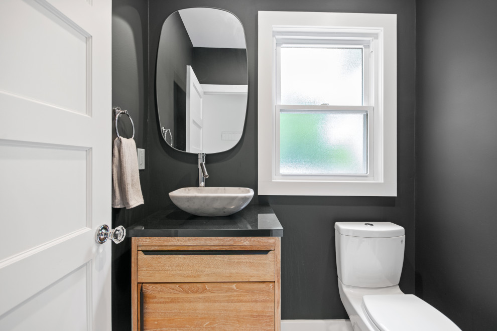 Inspiration for a small modern cloakroom in New York with freestanding cabinets, medium wood cabinets, a two-piece toilet, grey tiles, grey walls, ceramic flooring, a vessel sink, solid surface worktops, white floors and grey worktops.