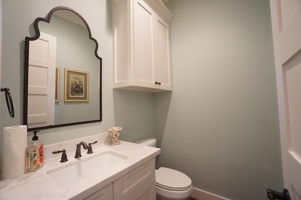 Kleine Klassische Gästetoilette mit Schrankfronten im Shaker-Stil, weißen Schränken, Wandtoilette mit Spülkasten, blauer Wandfarbe, Unterbauwaschbecken und Marmor-Waschbecken/Waschtisch in Houston