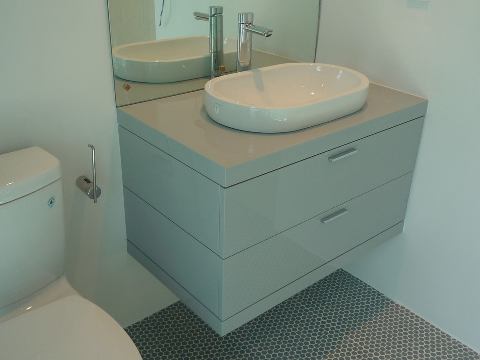 Foto di un piccolo bagno di servizio minimalista con ante lisce, ante beige, WC a due pezzi, pareti bianche, lavabo a bacinella, top in quarzo composito e pavimento grigio