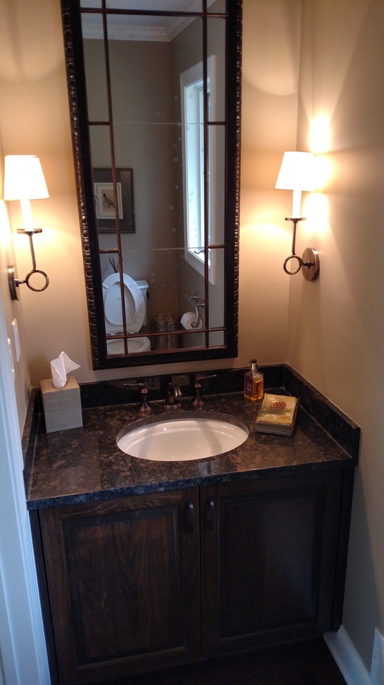 Powder room - small traditional dark wood floor powder room idea in Minneapolis with raised-panel cabinets, dark wood cabinets, beige walls, an undermount sink and granite countertops