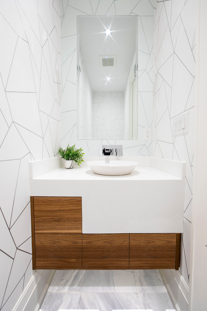 Cette photo montre un WC et toilettes tendance en bois brun de taille moyenne avec un placard à porte plane, un mur blanc, une vasque, un sol gris, un plan de toilette blanc, un sol en marbre et un plan de toilette en surface solide.