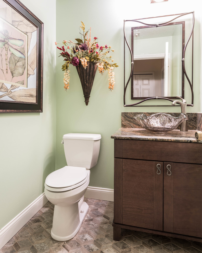 Inspiration pour un petit WC et toilettes traditionnel en bois foncé avec un placard à porte plane, un mur vert, un sol en carrelage de porcelaine, une vasque, un plan de toilette en granite et un sol multicolore.