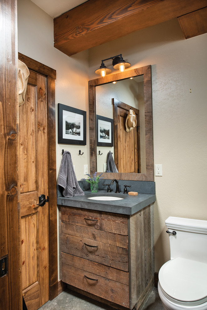Rustic cloakroom in Denver with flat-panel cabinets, dark wood cabinets, beige walls, a submerged sink, grey floors and grey worktops.
